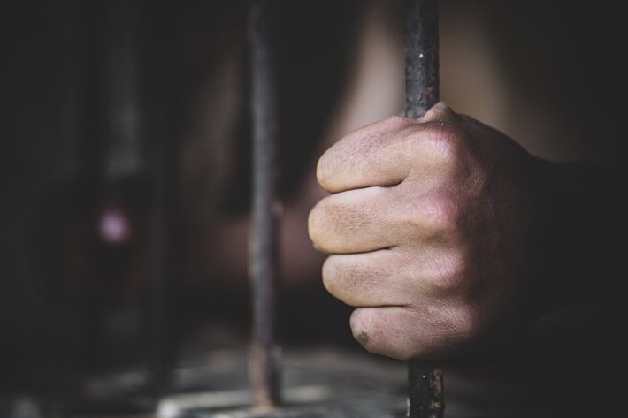 Prison holding onto bars