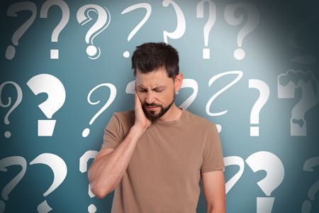 Man standing in front of question marks background