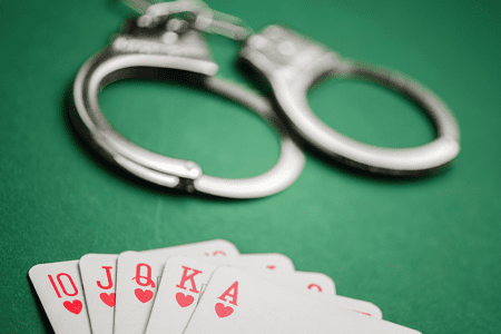 Handcuffs next to playing cards